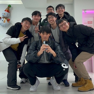 a group of young Asian men squatting in a group for a posed photo