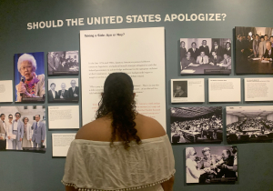 Yemale Febres '27 reading from a poster at a museum