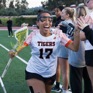 An Occidental lacrosse player celebrates with teammates