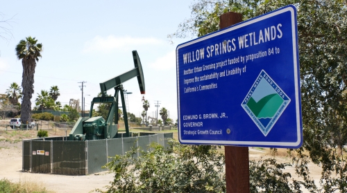 Oil wells pump next to the Willow Springs Wetlands preserve in Long Beach in May 2017.
