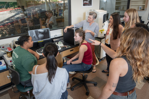Occidental College students and faculty gathered around equipment in the LUMEN lab on campus