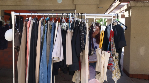 an Occidental College student looking through clothes on a rack at the Touchdown thrift store on campus