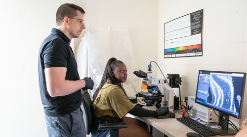 Professor Urstadt and student Daisy Ademoye in the Mind and Brain Lab looking at a computer