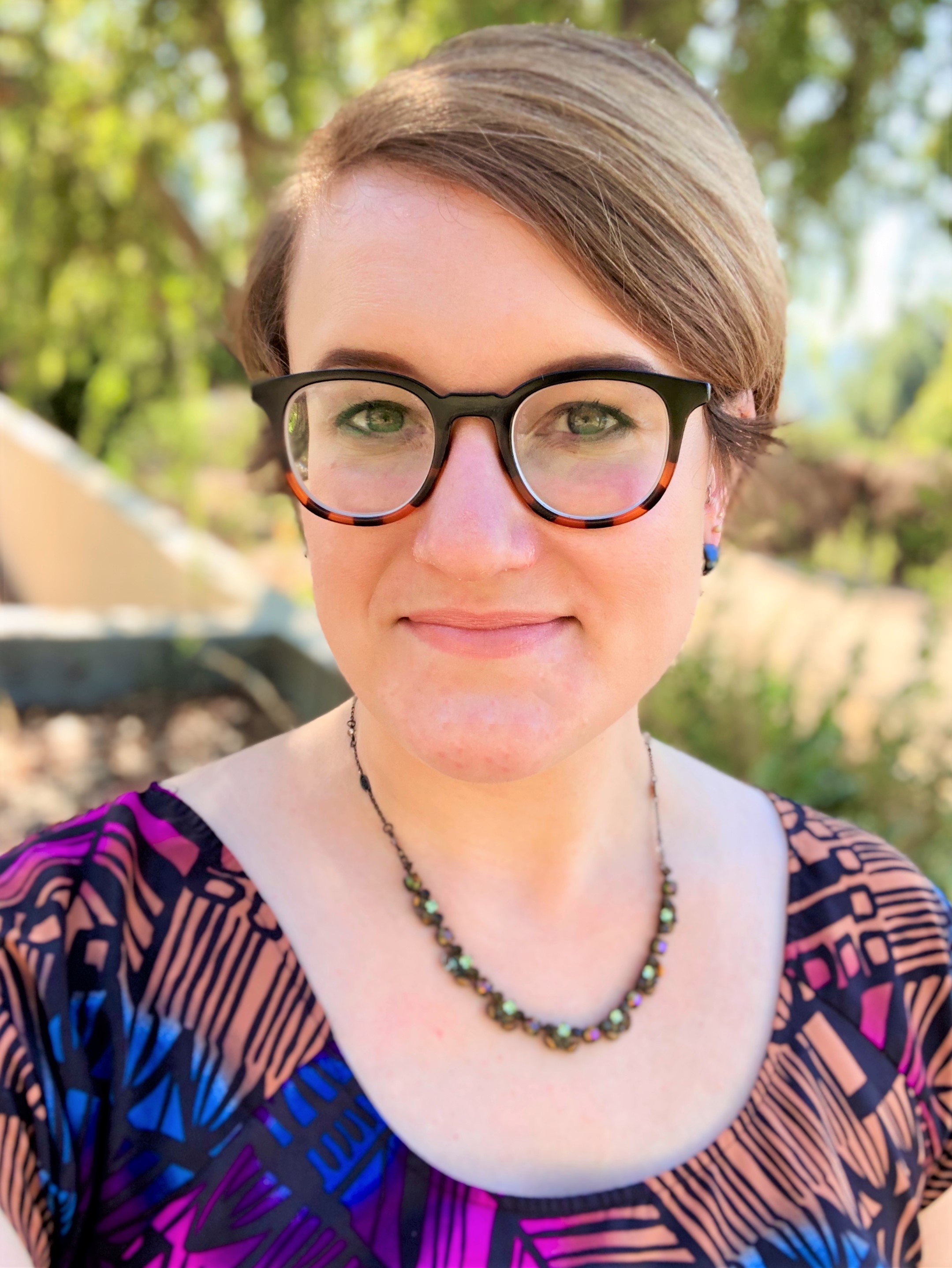 Professional headshot photo of Tirzah Blanche, outdoors on a sunny day, looking into camera and smiling